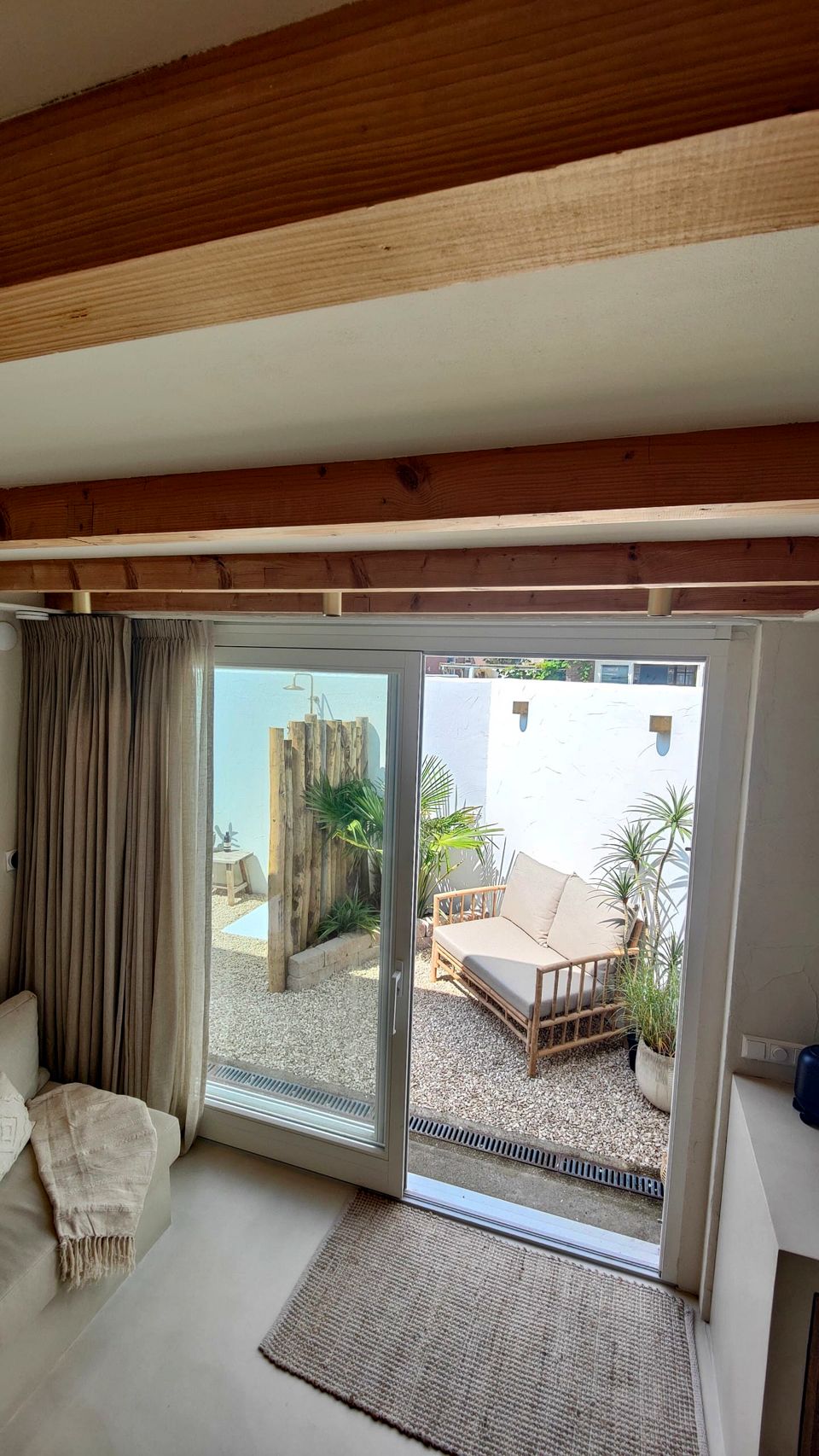 Door de grote schuifdeuren kijk je vanuit de woonkamer naar het terras