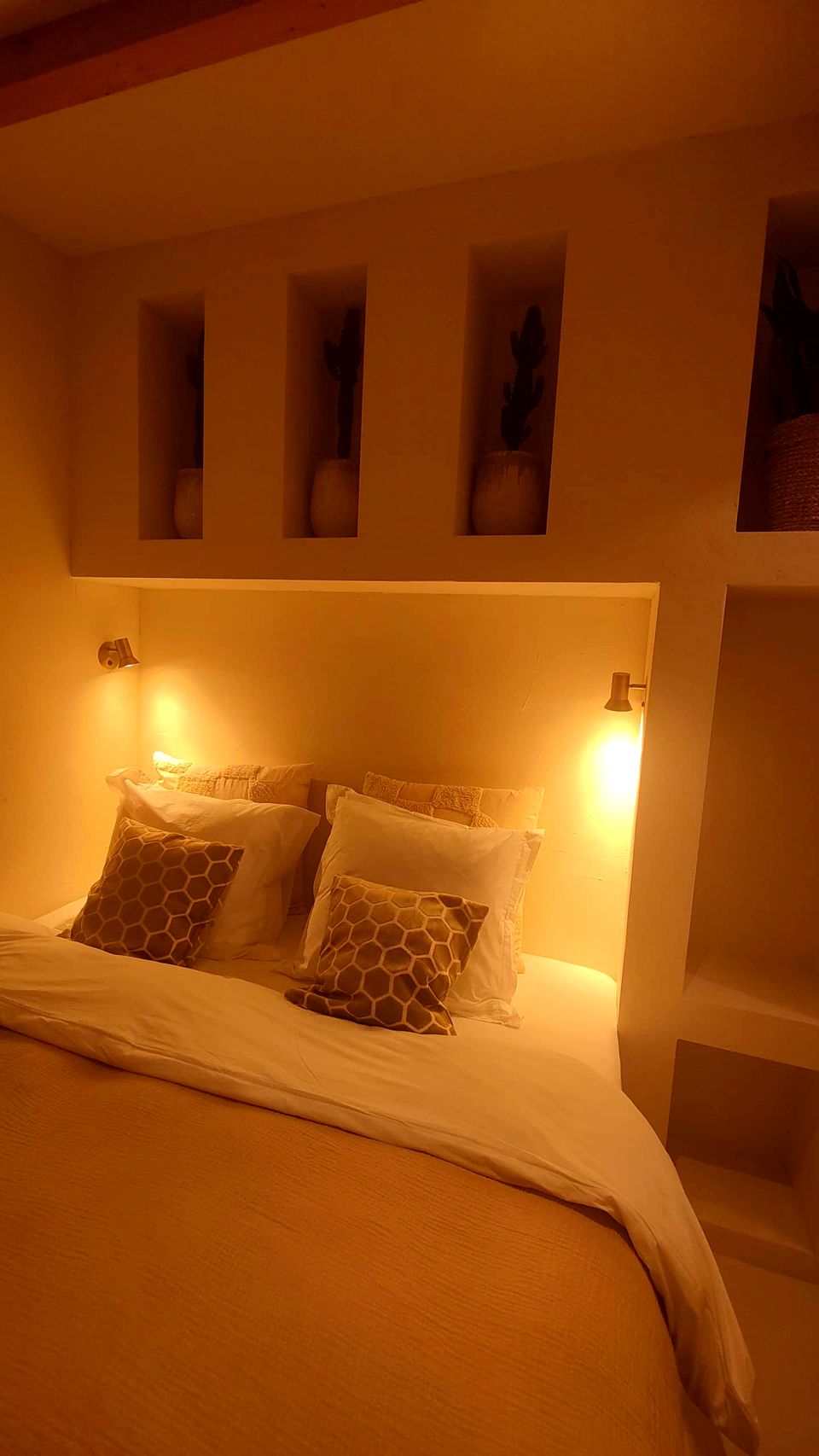 Het kingsize bed 's avonds met leeslampjes aan